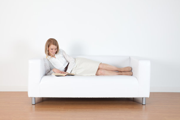 女商人斜靠在沙发上看书图片下载