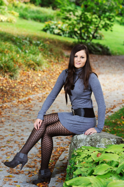 深褐色的年轻女子灰色羊毛连衣裙坐在Way Fall图片下载