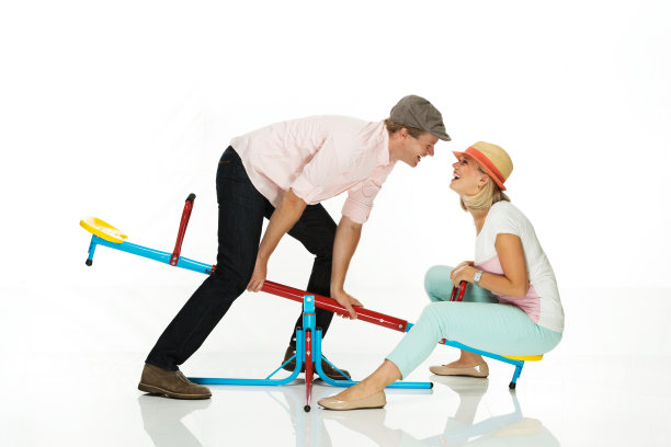 一对愉快的夫妇坐在跷跷板上图片下载