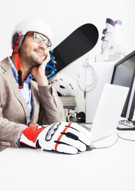 考虑冬季滑雪假期。办公室里的商人。图片下载