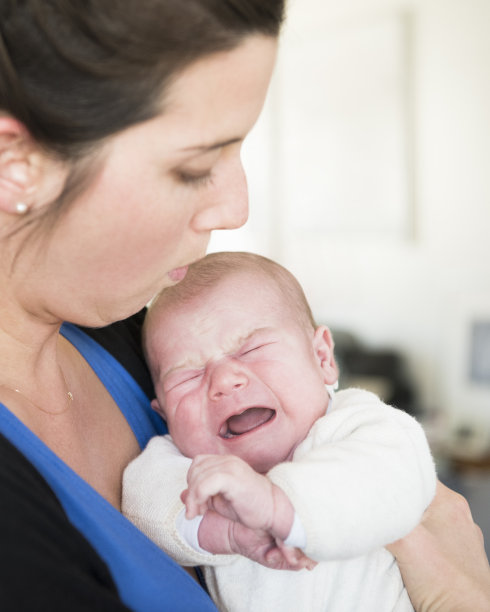 母亲在安慰哭闹的新生儿图片下载