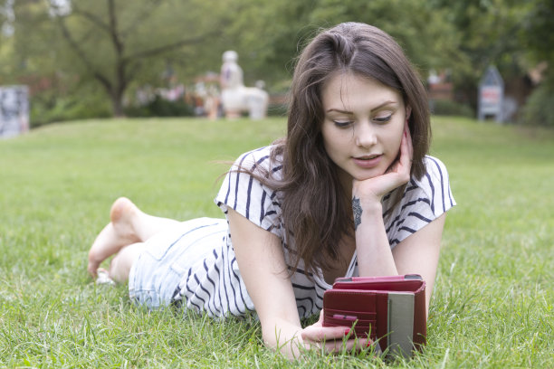 年轻女子在公园里看电子书或平板电脑图片下载