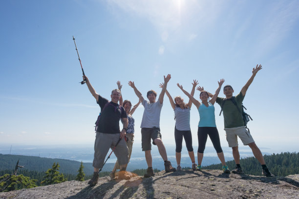 几代同堂的家人和朋友在山顶上伸开双臂庆祝图片下载