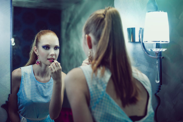 少女看着镜子化妆图片下载