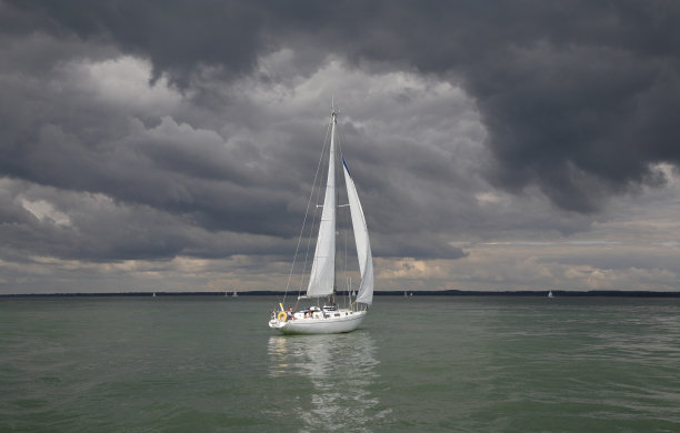 风暴来临前在平静海面上航行的游艇图片下载