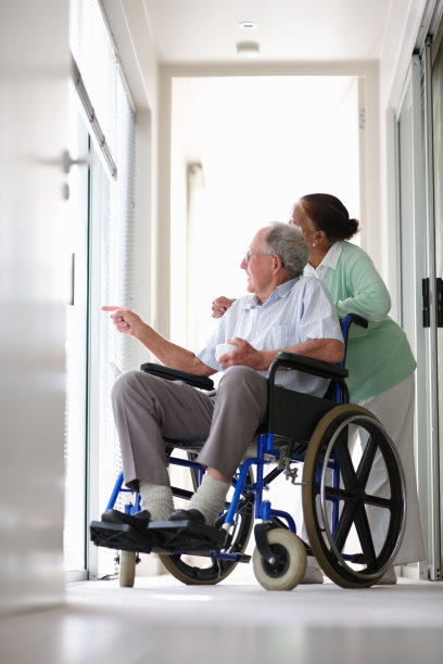 一位坐在轮椅上的老人，妻子在他的帮助下图片下载
