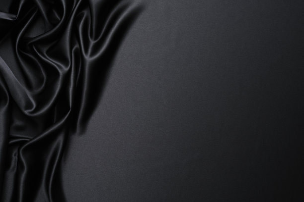 特写的黑色缎子波浪背景与复制空间素材图片