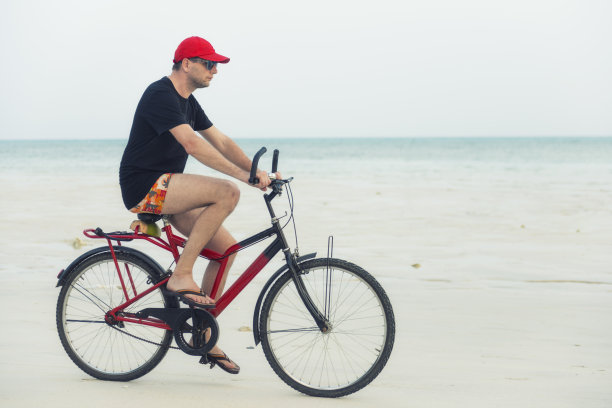 一个人在空旷的海滩上骑着自行车图片下载