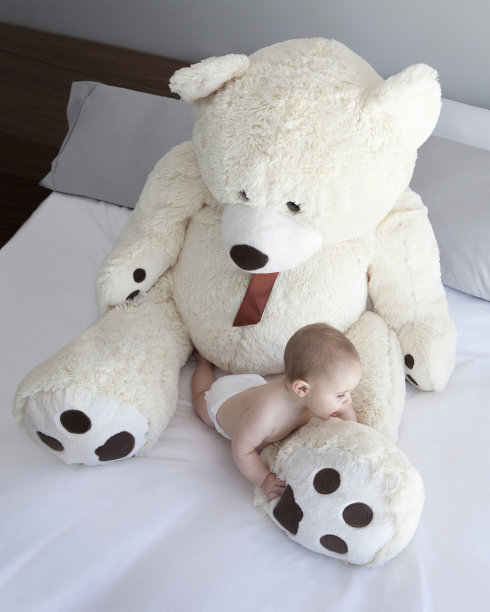 小男孩在玩他的大泰迪熊图片下载