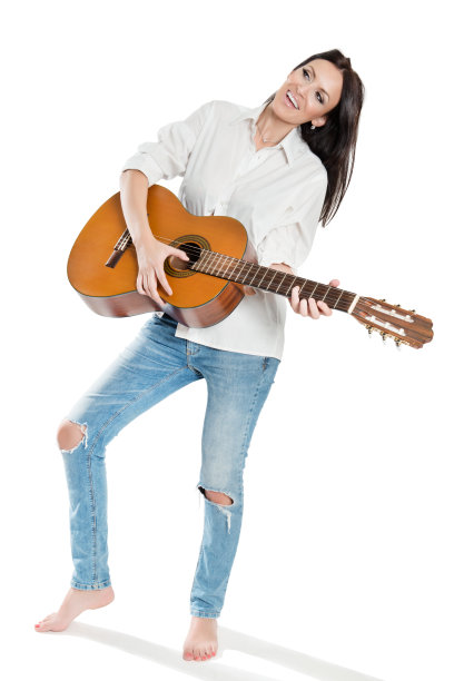 有吸引力的快乐的年轻女子与吉他摆姿势图片下载
