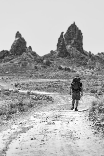 一名男子在沙漠路上徒步旅行图片下载
