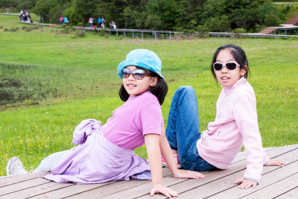 两个亚洲女孩在草地上图片下载