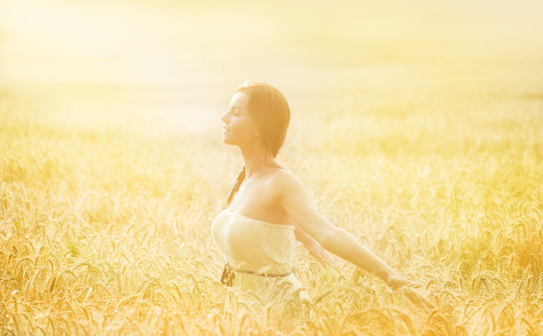 快乐的女孩享受自由在日落的田野图片下载