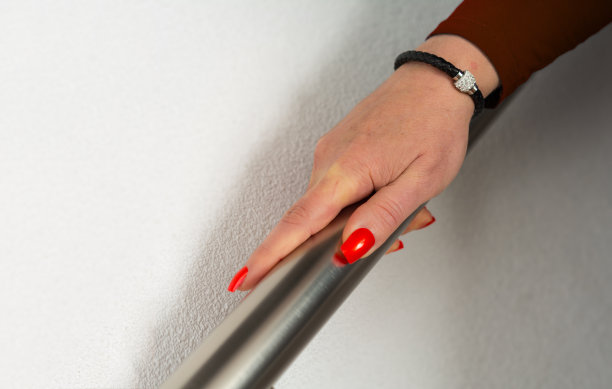 成熟的女人下楼梯时专注于自己的手图片下载