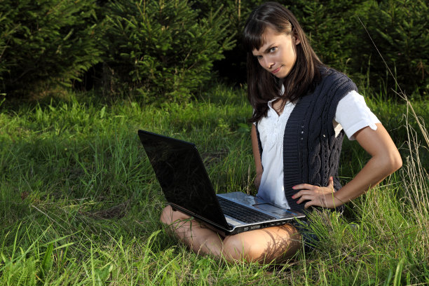拥有笔记本电脑的漂亮年轻女人图片下载
