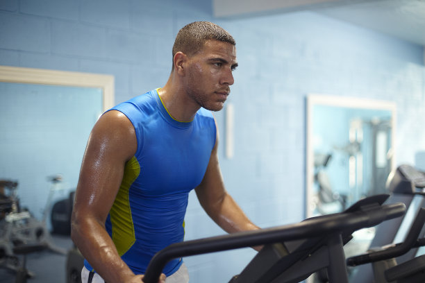 年轻人在健身房里的跑步机上图片下载