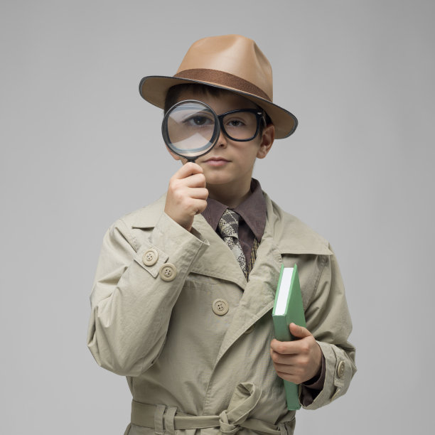 小侦探透过放大镜看灰色背景图片下载