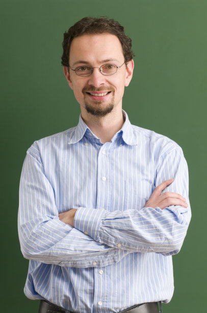 一位老师站在那里，双臂交叉，面带微笑图片下载