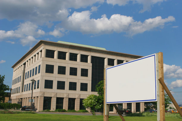 现代办公大楼与空白的房地产标志图片下载