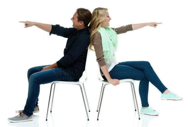 幸福的一对坐在椅子上，指着图片下载