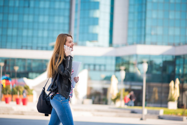 一个正在走路和使用手机的女人图片下载