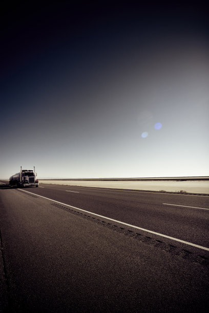 在平坦公路上孤独的半卡车和拖车图片下载
