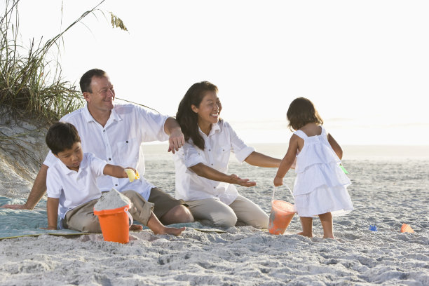 跨种族家庭，孩子们在海滩上玩耍图片下载