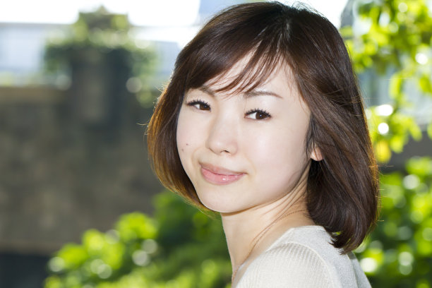 年轻的亚洲女人回首和微笑图片下载