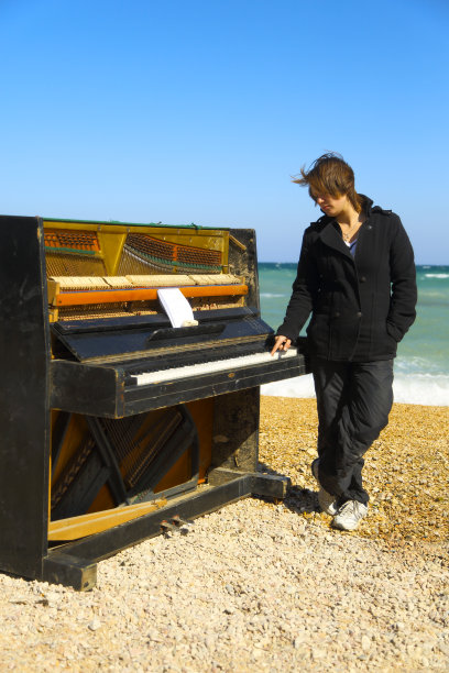 一个年轻女子在一架旧钢琴上弹奏图片下载