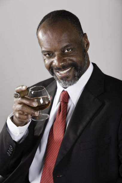 成熟的黑色男性与白兰地和雪茄图片下载