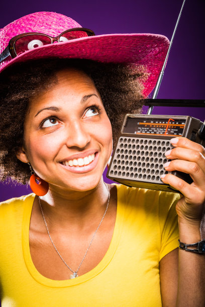 快乐的年轻女子在听老式调频收音机里的音乐图片下载