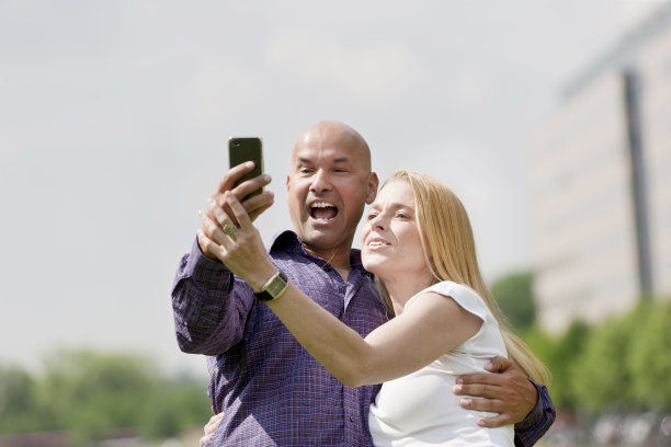 欢笑的夫妇和智能手机图片下载