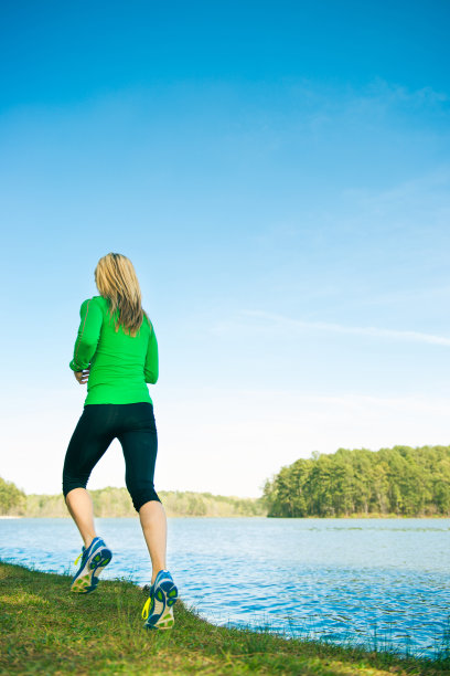 在湖边跑步的健康女人图片下载