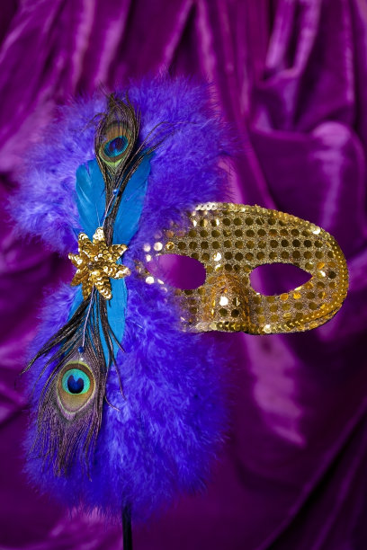 金色的狂欢节面具，紫色和蓝色的羽毛。图片下载