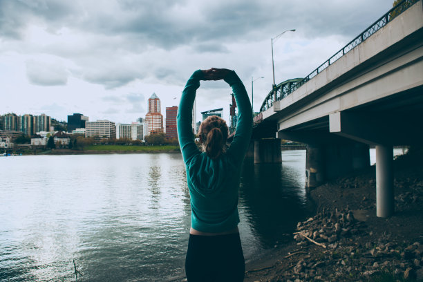 运动的年轻女子在城市跑步后伸展图片下载