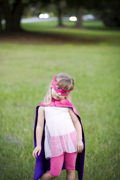 超级英雄女孩站在草地上图片下载