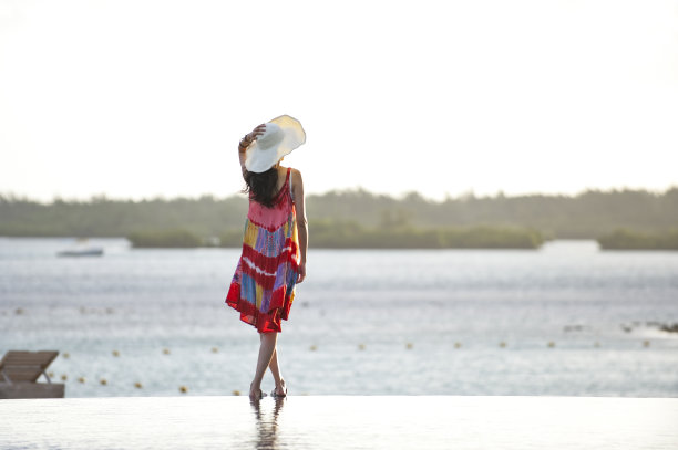 一个女人站在游泳池边上图片下载