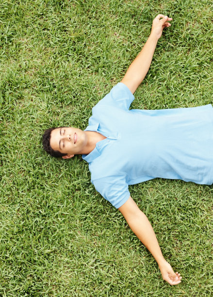 俯视图一个年轻人放松在草地上图片下载