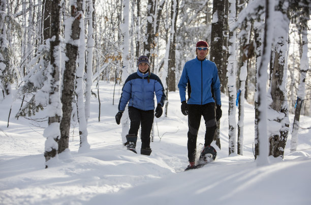 一对穿雪鞋的夫妇在一个晴朗的冬日在中西部。图片下载