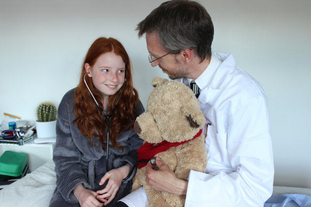 有趣的医生和女病人，带着泰迪熊和听诊器图片下载