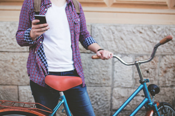 一个英俊的男人拿着智能手机在城市里的照片图片下载