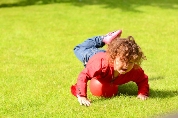 甜美的女孩在花园里玩球图片下载