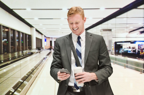 兴高采烈的商人在机场使用手机图片下载