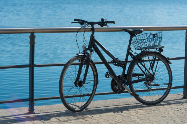 在城市水边的栏杆上骑自行车图片下载
