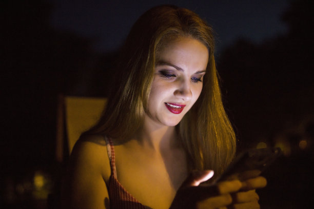 晚上用智能手机的女人图片下载