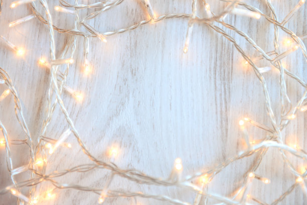 白色木制背景上的圣诞彩灯图片下载