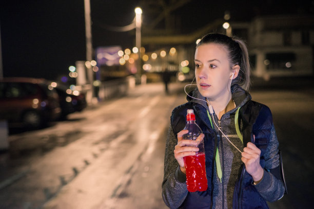 健身女性在晚上跑步后休息一会儿图片下载