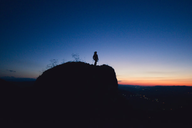 山顶上女性攀岩者的剪影图片下载