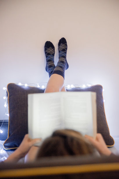 女人在床上看书的柔软照片图片下载