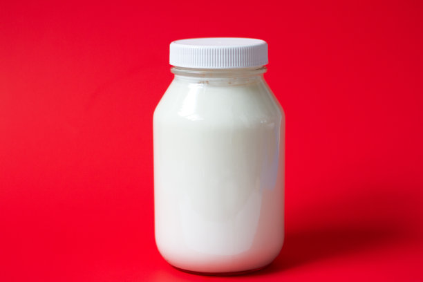 红色背景上的希腊酸奶罐图片下载